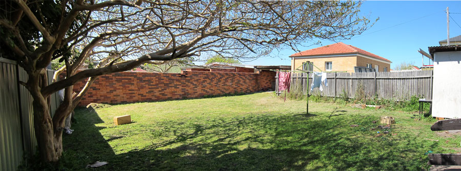 Before: the empty Kogarah backyard prior to the studio addition, brick side wall and rear boundary fence